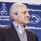 Penn State President Graham Spanier looks on as head football coach Joe Paterno holds a plaque commemorating his 409th collegiate win.