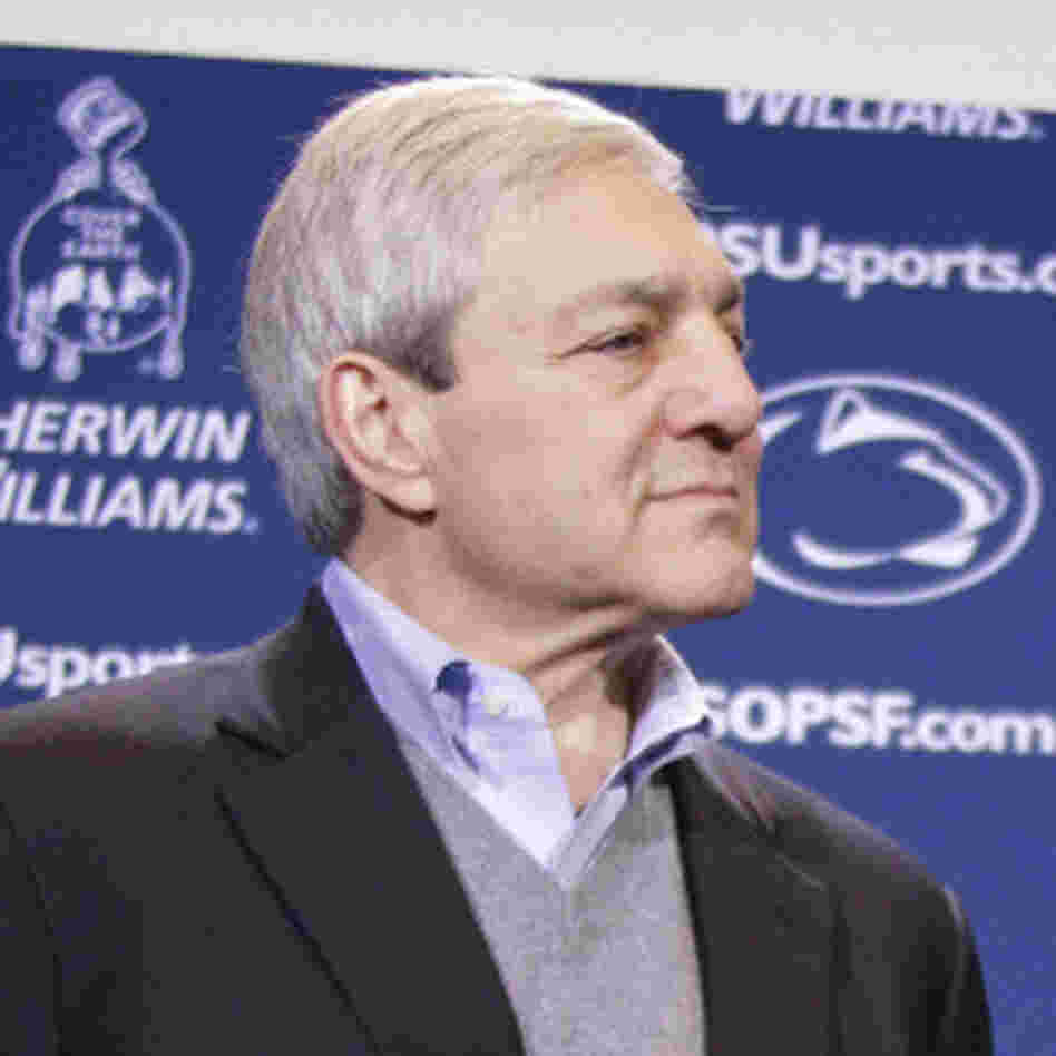 Penn State President Graham Spanier looks on as head football coach Joe Paterno holds a plaque commemorating his 409th collegiate win.