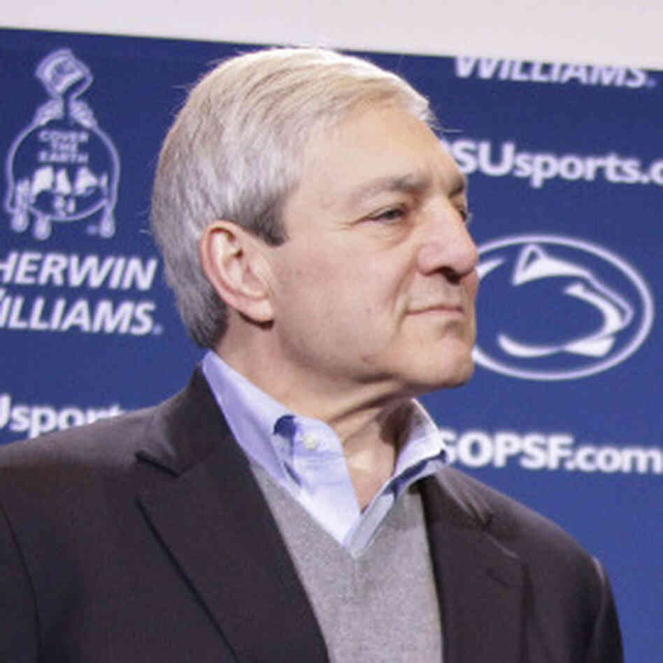 Penn State President Graham Spanier looks on as head football coach Joe Paterno holds a plaque commemorating his 409th collegiate win.