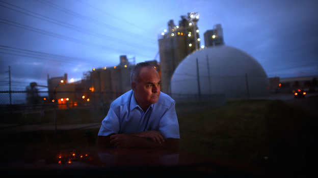 Jeff Galemore leans on his pickup truck near the Ash Grove Cement plant in Chanute, Kan. He and his family are concerned about the toxic emissions and are fighting for independent testing downwind.