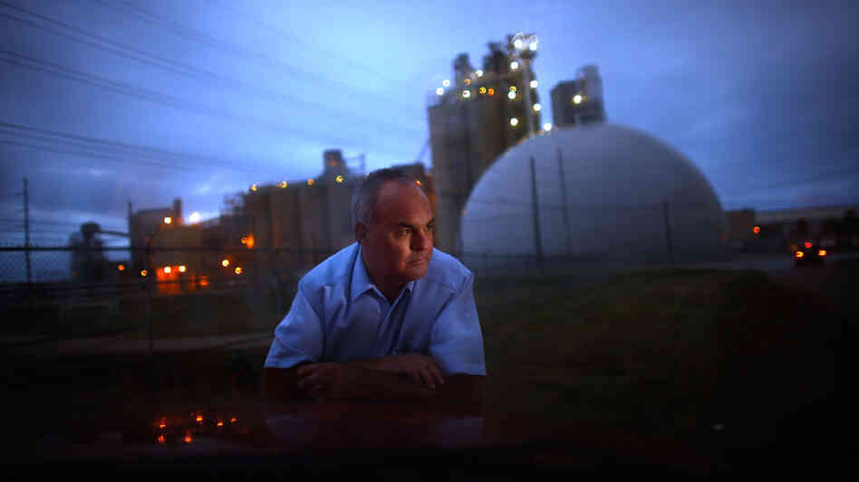 Jeff Galemore leans on his pickup truck near the Ash Grove Cement plant in Chanute, Kan. He and his family are concerned about the toxic emissions and are fighting for independent testing downwind.