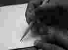 A hand taking a pencil to paper.
