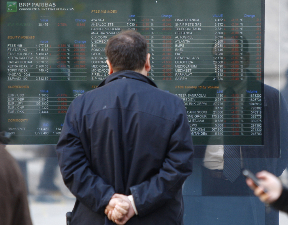 A man checks a stock exchange monitor outside a bank in Milan, Italy. Italy's key borrowing rate spiked Wednesday well above the 7 percent level that eventually forced other eurozone countries to seek bailouts.