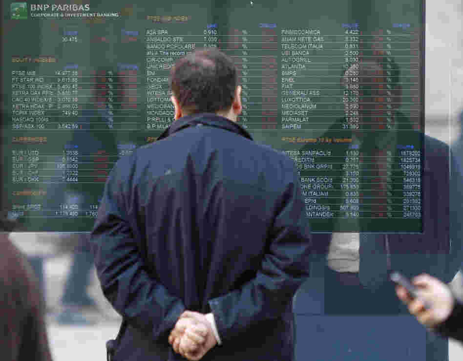 A man checks a stock exchange monitor outside a bank in Milan, Italy. Italy's key borrowing rate spiked Wednesday well above the 7 percent level that eventually forced other eurozone countries to seek bailouts.