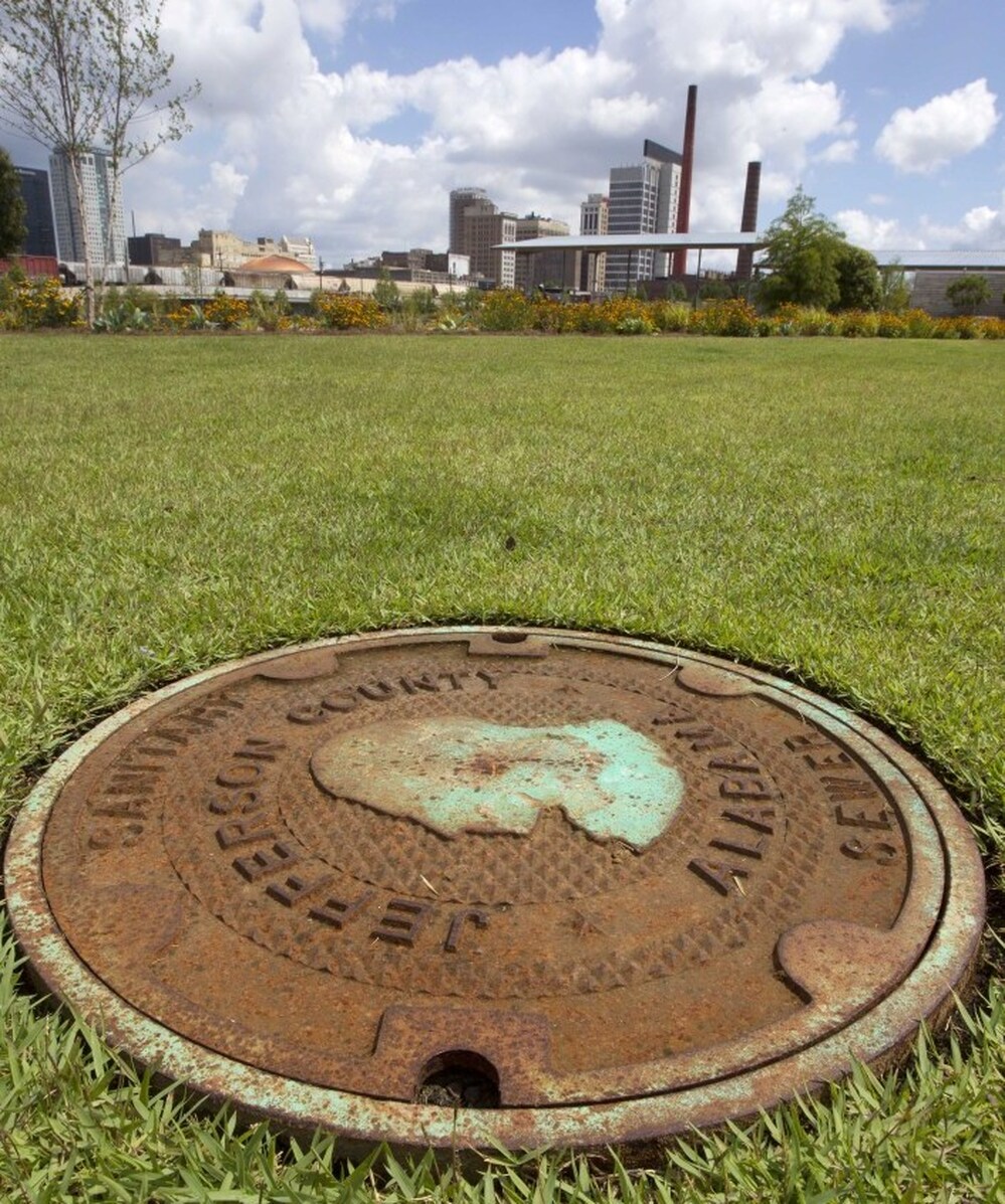 This file photo shows a Jefferson County sewer manhole cover in Railroad Park in Birmingham, Ala. Leaders of Alabama's most populous county voted to file an estimated $4.1 billion bankruptcy.