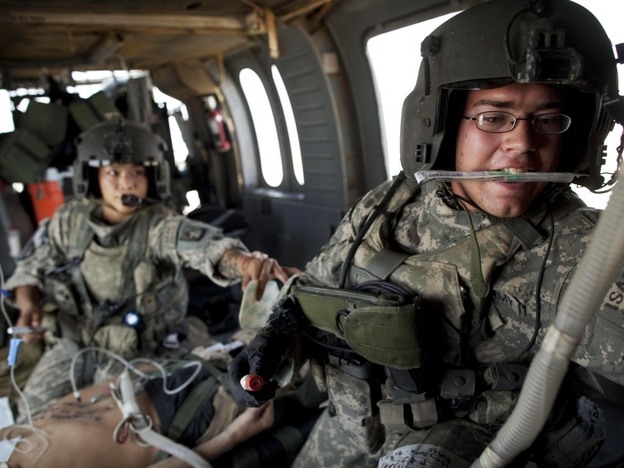 Army flight medics work on a Marine who was wounded by an improvised explosive device, or IED, in southern Afghanistan.