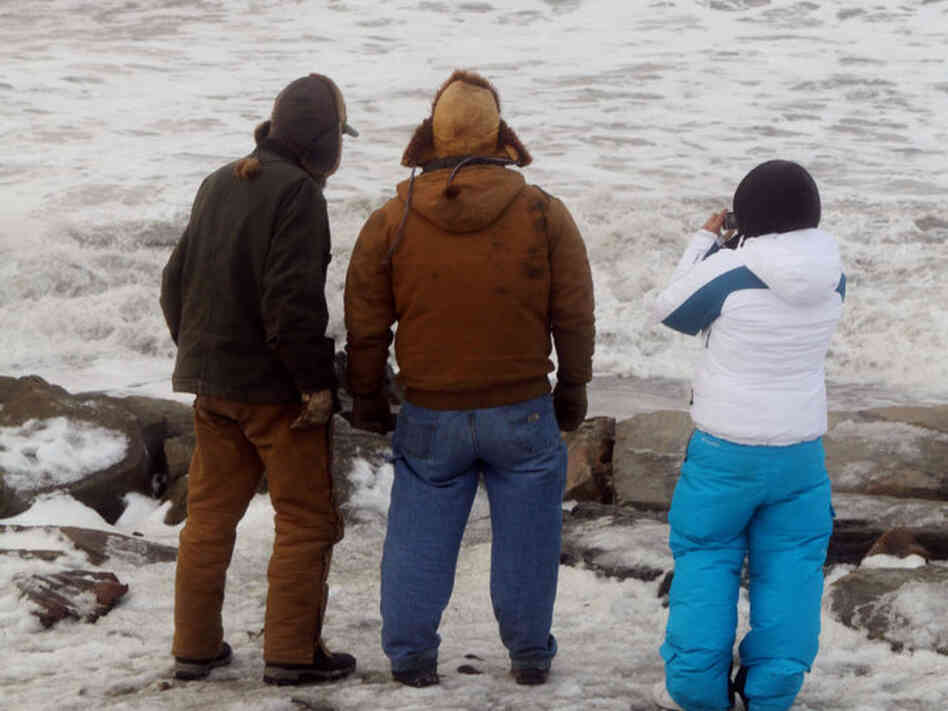 A trio get a closer look at the large waves cresting over the seawall just south of Nome's Front Street in Nome, Alaska, Wednesday., Nov. 9, 2011.