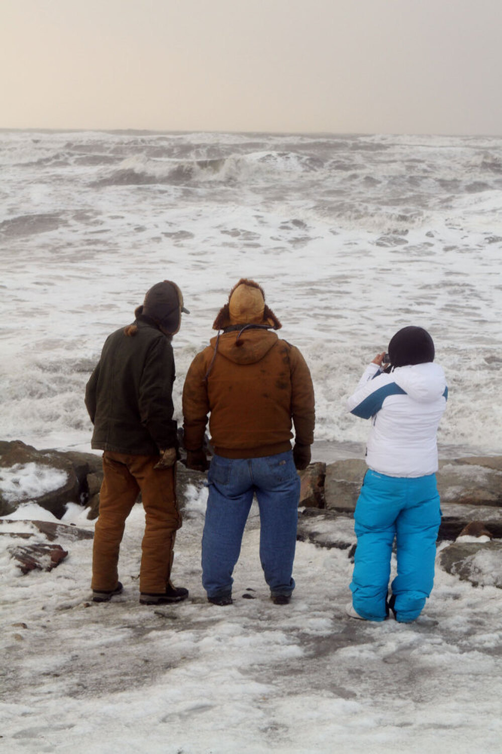 A trio get a closer look at the large waves cresting over the seawall just south of Nome's Front Street in Nome, Alaska, Wednesday., Nov. 9, 2011.