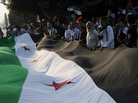 Pro-democracy protesters, holding a huge pre-Baath era Syrian flag outside the Arab league headquarters in Cairo on November 2, 2011. Pro-democracy protesters, holding a huge pre-Baath era Syrian flag outside the Arab league headquarters in Cairo on November 2, 2011.
