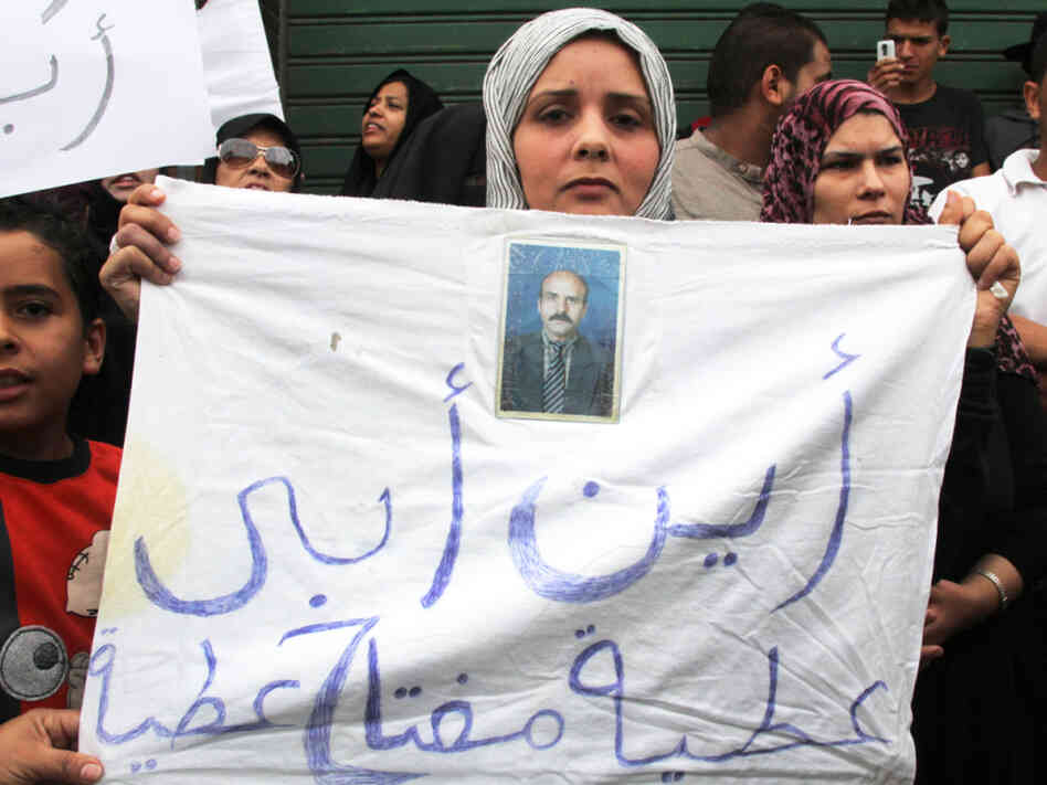 A woman outside the Hudba el-Gassi compound in Tripoli, Libya, holds up a sign asking, "Where's my father?" Once a military police base, Hudba el-Gassi is now a makeshift prison for regime loyalists and others rounded up by armed militiamen. 
