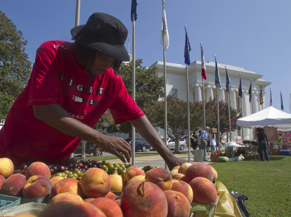 Desmond Brown sells fruits and vegetables at a farmer's market outside the Alabama Capitol in Montgomery, Ala.