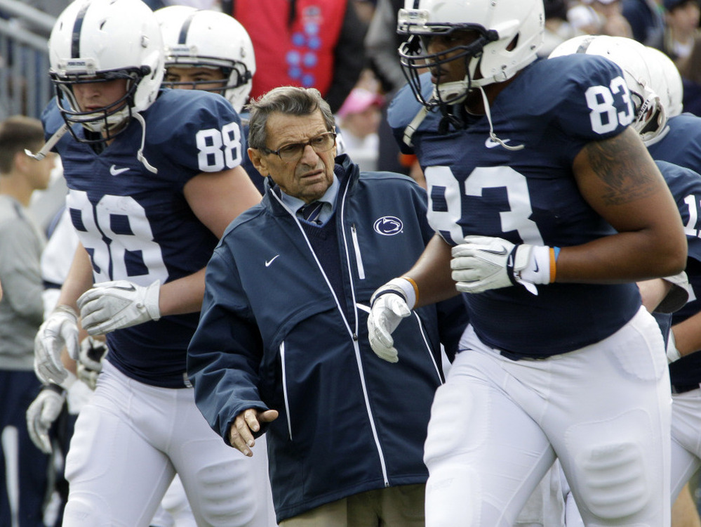 Then-Penn State head coach Joe Paterno gets out of the way during warm-ups before an NCAA college football game in State College, Pa., last month.