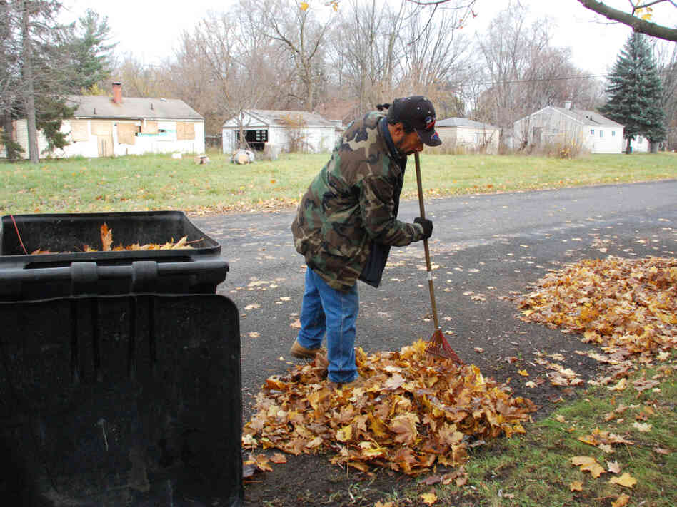 Detroit resident Kevin Garcia rakes leaves in front of his home. Abandoned homes are everywhere in his neighborhood. Detroit resident Kevin Garcia rakes leaves in front of his home. Abandoned homes are everywhere in his neighborhood.
