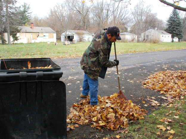Detroit resident Kevin Garcia rakes leaves in front of his home. Abandoned homes are everywhere in his neighborhood. Detroit resident Kevin Garcia rakes leaves in front of his home. Abandoned homes are everywhere in his neighborhood.
