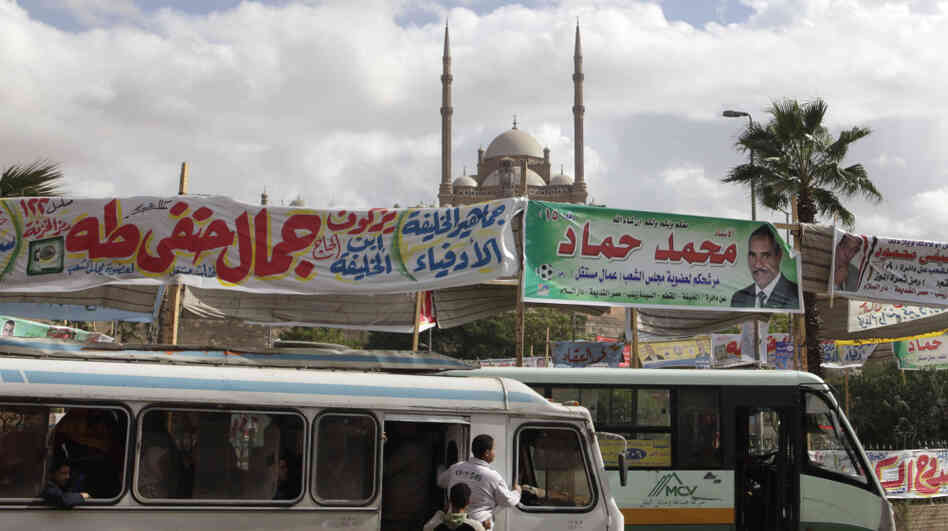 Election banners hang near buses in Cairo on Monday. Parliamentary elections — the first since the end of President Hosni Mubarak's decades-long rule — will begin Nov. 28. Groups with Islamist ties are expected do well in the polls.