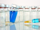 A bottle of blue medicine teeters. A bottle of blue medicine teeters.