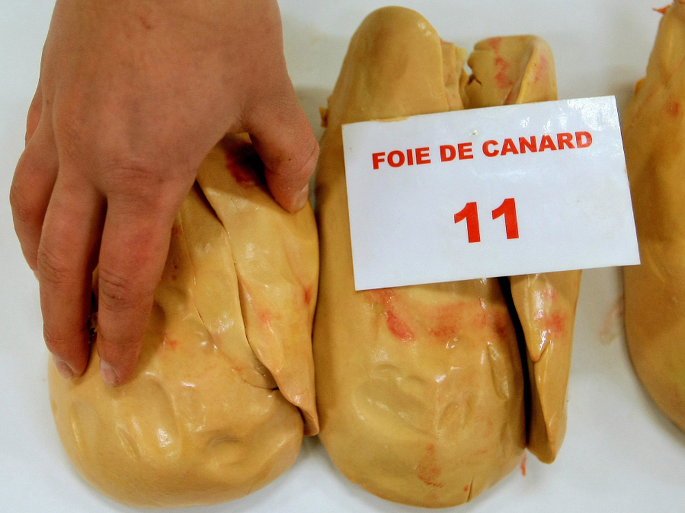 A jury member feels a piece of duck foie gras during a contest of local producers and producers from southwestern France. 