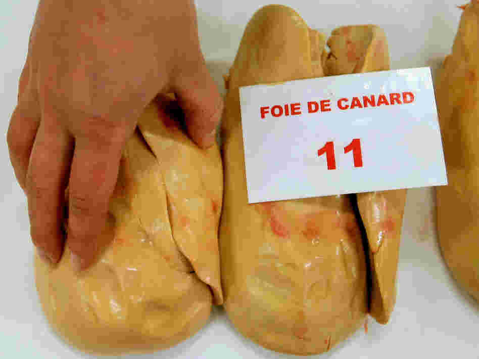 A jury member feels a piece of duck foie gras during a contest of local producers and producers from southwestern France. 