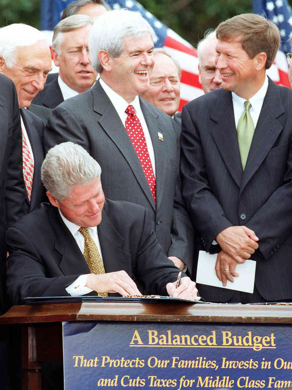 Gingrich stands with then-Republican Rep. John Kasich of Ohio while President Clinton signs the balanced-budget agreement in August 1997.