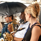 A member of the Mingus Big Band takes shelter from the rain. A member of the Mingus Big Band takes shelter from the rain.