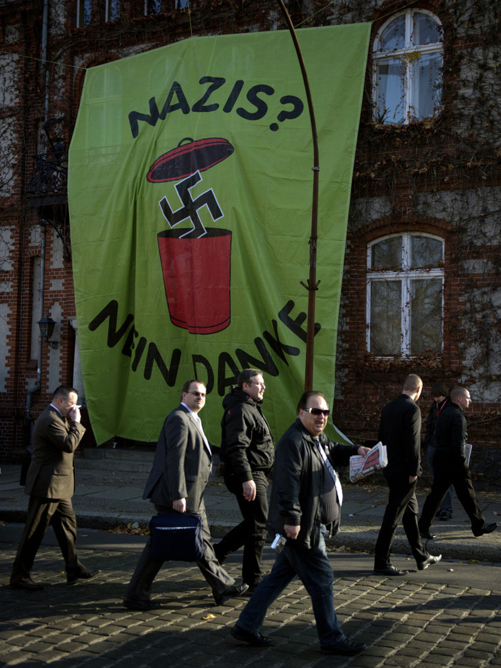 Supporters of Germany's far-right National Democratic Party walk past a huge banner reading "Nazis? No, thanks" as they arrive to attend a party congress on Nov. 12 in Neuruppin, northeastern Germany. 