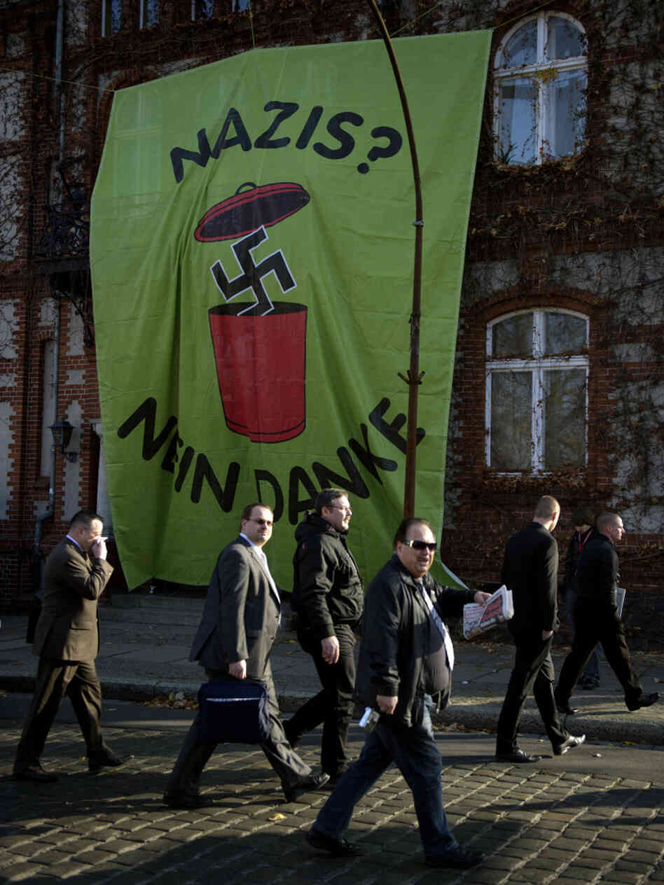 Supporters of Germany's far-right National Democratic Party walk past a huge banner reading "Nazis? No, thanks" as they arrive to attend a party congress on Nov. 12 in Neuruppin, northeastern Germany. 