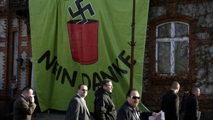 Supporters of Germany's far-right National Democratic Party walk past a huge banner reading "Nazis? No, thanks" as they arrive to attend a party congress on Nov. 12 in Neuruppin, northeastern Germany.