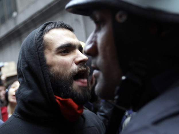 A demonstrator (left) and a police officer, in Manhattan's financial district earlier today. 