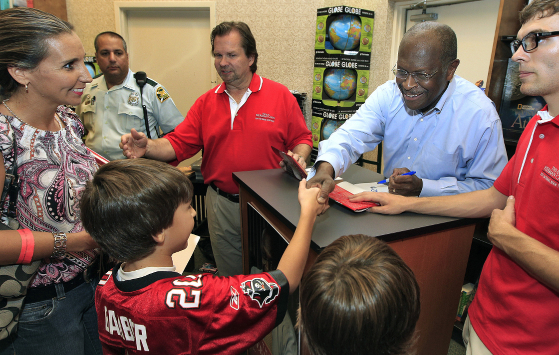 Republican presidential candidate Herman Cain shakes hands with a family during an Oct. 5 book signing in Florida. 