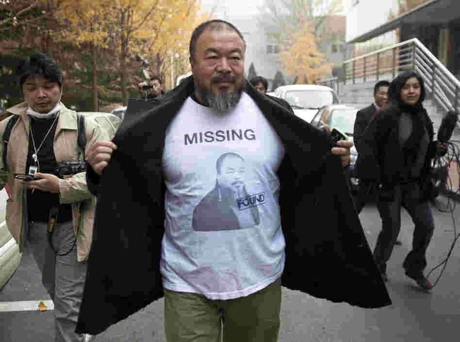 Chinese dissident artist Ai Weiwei opens his jacket to reveal a shirt bearing his portrait as he walks into the Beijing Local Taxation Bureau. Chinese dissident artist Ai Weiwei opens his jacket to reveal a shirt bearing his portrait as he walks into the Beijing Local Taxation Bureau.