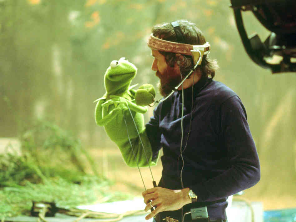 Like Muppets creator Jim Henson (with Kermit, above, in the 1970s), current Muppeteers (including Bill Barretta, below, with Pepe the Prawn) wear head-mounted microphones to capture their voice work. 