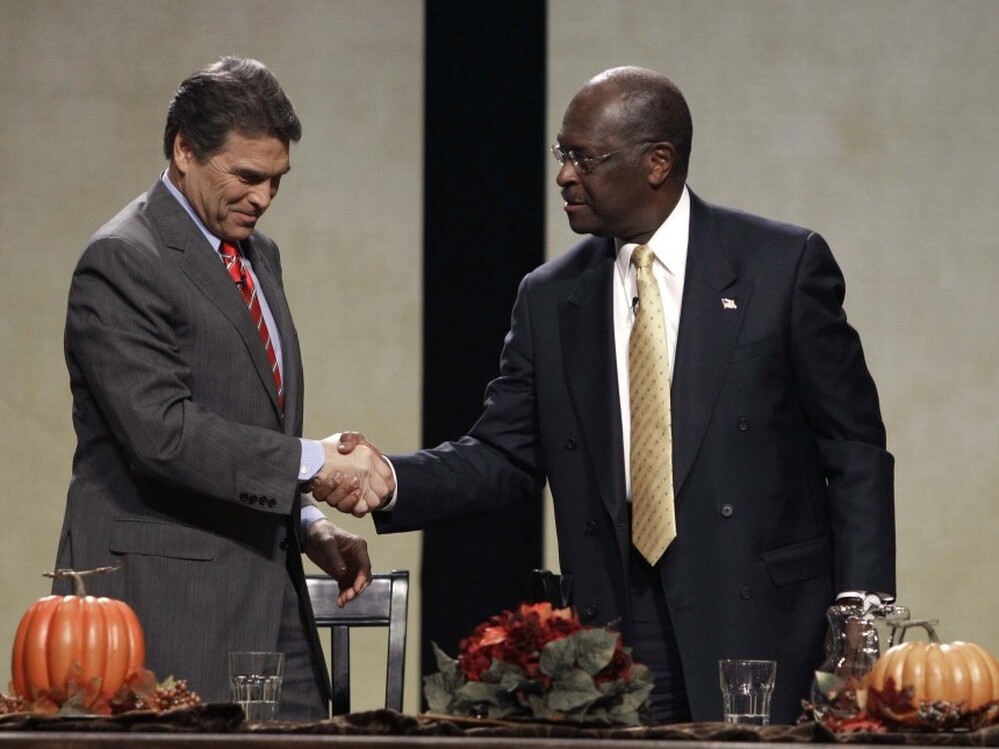 Republican presidential candidates Texas Gov. Rick Perry and former CEO of Godfather's Pizza Herman Cain talk after a forum sponsored by The Family Leader Saturday. Both men let their emotions show during the roundtable.