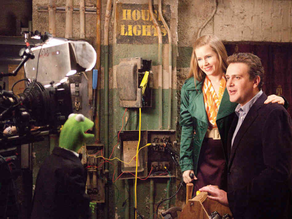 Kermit the Frog does the backstage-chat thing with Amy Adams and Jason Segel in The Muppets.