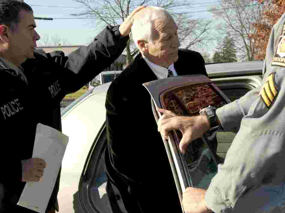 Gerald "Jerry" Sandusky, center, is placed in a police car in Bellefonte, Pa. on Saturday, Nov. 5.