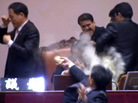 This still image taken from video shows lawmaker Kim Sun-Dong (bottom) of the Democratic Labor Party detonating a tear gas canister and throwing it toward the chairman's seat at the National Assembly. This still image taken from video shows lawmaker Kim Sun-Dong (bottom) of the Democratic Labor Party detonating a tear gas canister and throwing it toward the chairman's seat at the National Assembly.