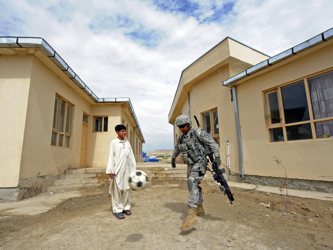 U.S. Army Sgt. Johnny Hoyos plays soccer with an Afghan boy at a school in Qalat, Afghanistan on April 16 in Qalat. U.S. troops were visiting to assess the facilities for a renovation project.