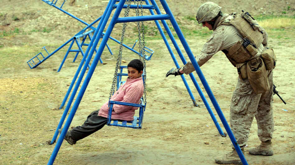 A U.S. Marine pushes a child on a swing in southern Afghanistan on March 4. After a decade of nation-building in Afghanistan, and nearly as long in Iraq, the U.S. appears to be losing it appetite for such efforts.