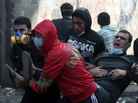 Egyptian protesters carried away a man suffering from tear gas during clashes with riot police earlier today near Tahrir Square, in Cairo.