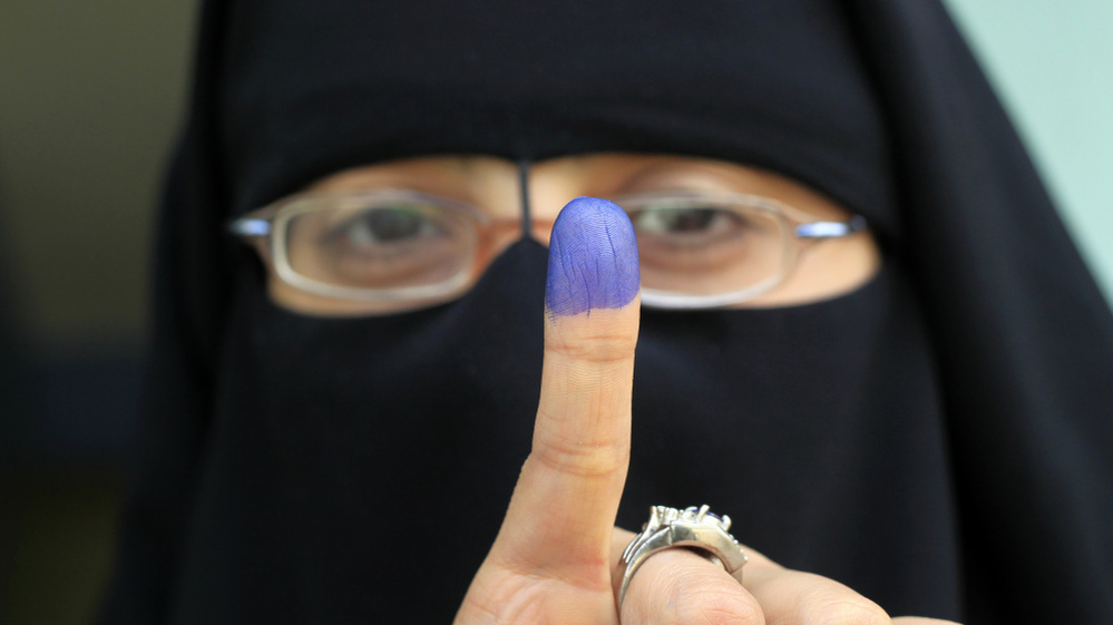 An Egyptian woman shows her ink-stained finger after voting at a polling station in the Manial neighborhood of Cairo earlier today (Nov. 28, 2011).