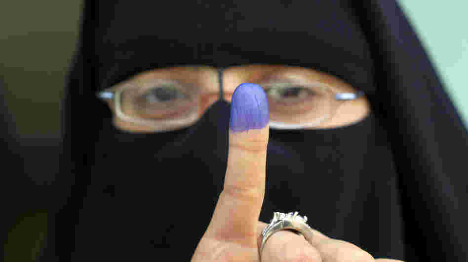 An Egyptian woman shows her ink-stained finger after voting at a polling station in the Manial neighborhood of Cairo earlier today (Nov. 28, 2011).