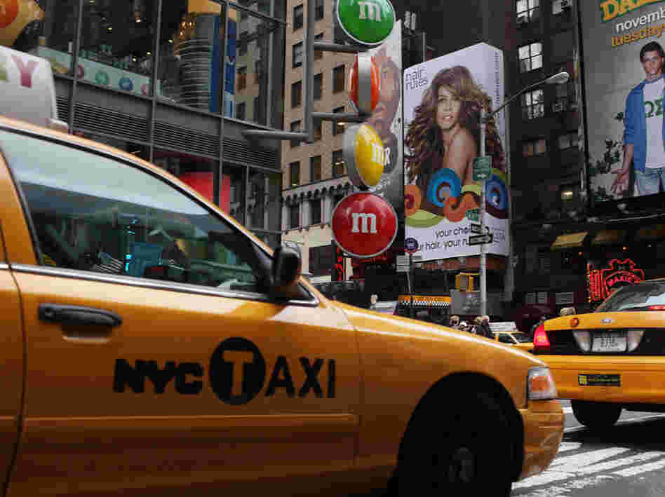 Taxis pass through Times Square in New York City. Taxis pass through Times Square in New York City.