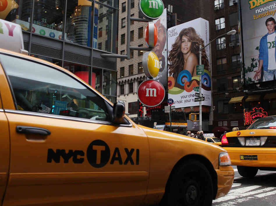 Taxis pass through Times Square in New York City. Taxis pass through Times Square in New York City.