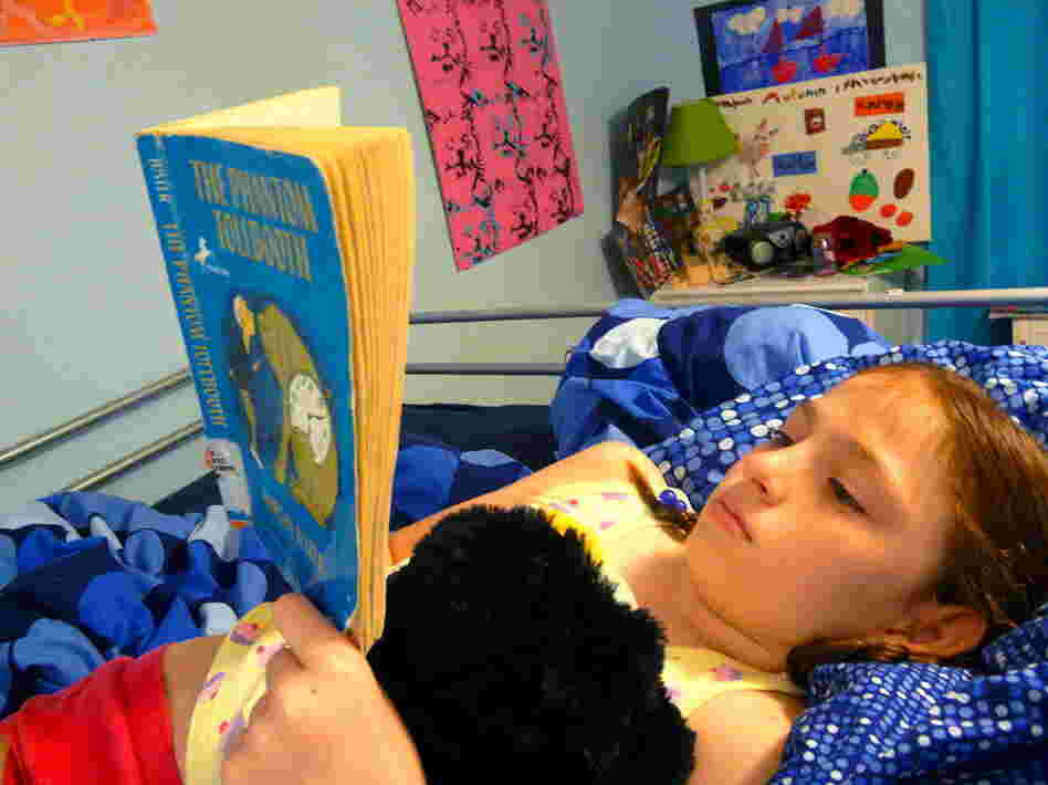Rory Pennington, 8, relaxes with The Phantom Tollbooth at home in Jacksonville, Fla.