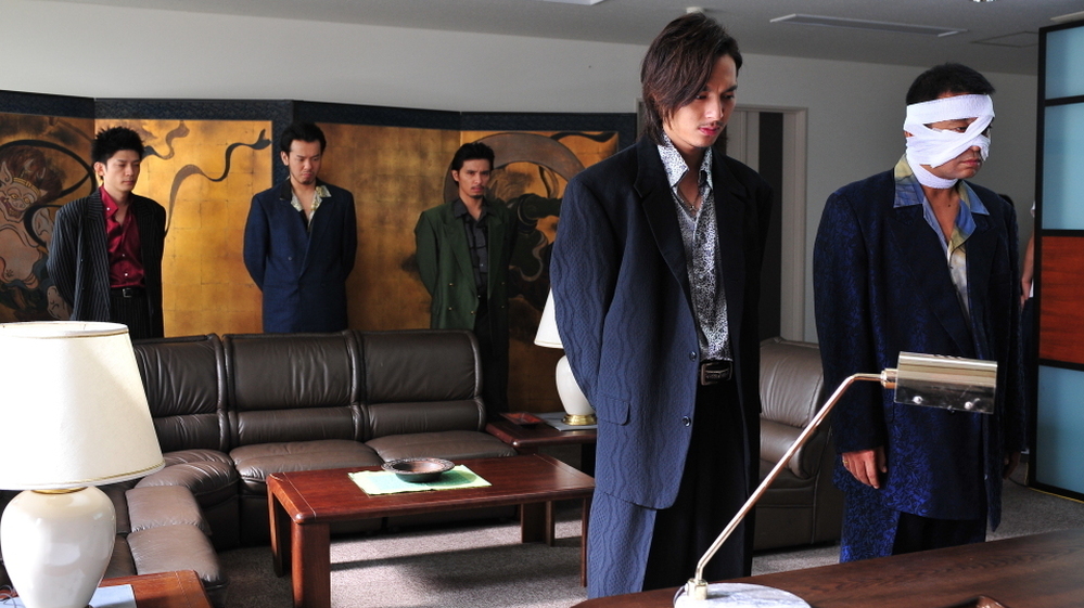 After Takeshi's Otomo maims one of the Murase clan, Iizuka (Takashi Tsukamoto, left foreground) and Kimura (Hideo Nakono, bandaged) plan an in-kind response.