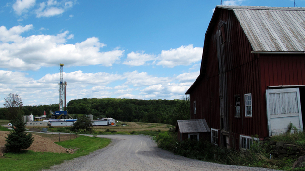 A drilling rig looms behind a barn in Tioga County, Pa. A drilling rig looms behind a barn in Tioga County, Pa.