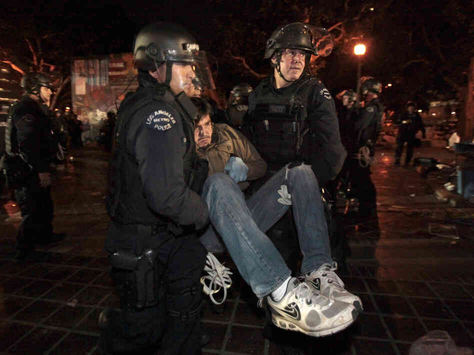 An Occupy protester is arrested early today in Los Angeles as authorities cleared the site near city hall that had been occupied for two months.