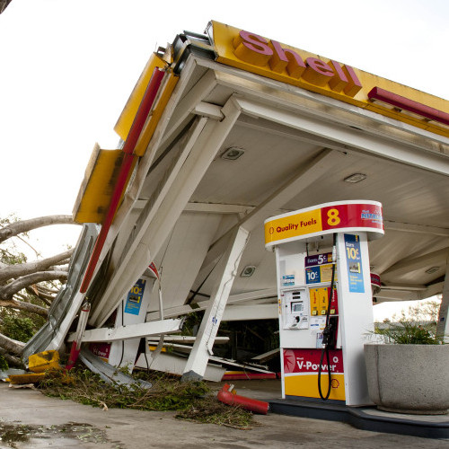 Keith Curo, of Pasadena, stops to look over the damage caused by a fallen tree at a Shell gas station Thursday, Dec. 1, 2011, in Pasadena, Calif. 