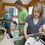 A Kansas City family prepares a meal together. A new study finds that working mothers log more hours — and get more stressed — than working fathers while multitasking at home. (This family wasn't part of the research.) A Kansas City family prepares a meal together. A new study finds that working mothers log more hours — and get more stressed — than working fathers while multitasking at home. (This family wasn't part of the research.)