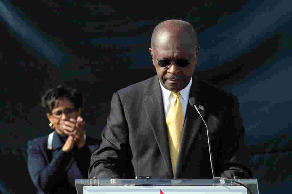 With his wife, Gloria, standing behind him, Herman Cain announces that he is suspending his run for the GOP presidential nomination, outside his campaign headquarters in Atlanta on Dec. 3. 