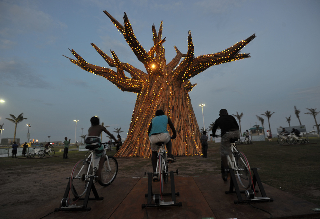 South Africans light up a Baobab tree by riding bikes in Durban as part of a renewable energies display on the beach front during the United Nations Climate Change Conference.